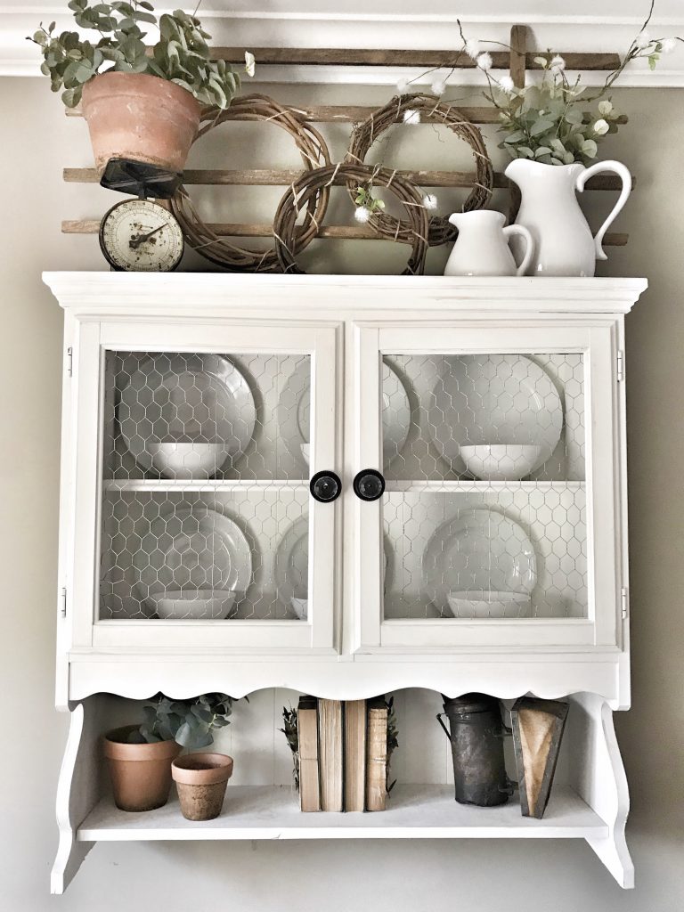 hanging hutch with greenery and clay pots