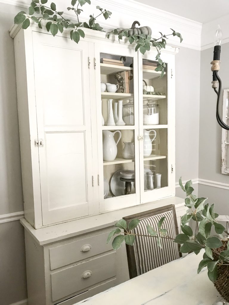 white hutch decorated with white dishes