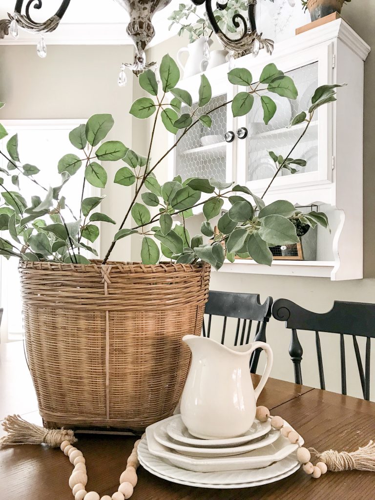 basket with greenery and white pitcher