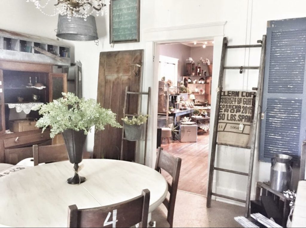 round farmhouse table and old ladder in antique booth