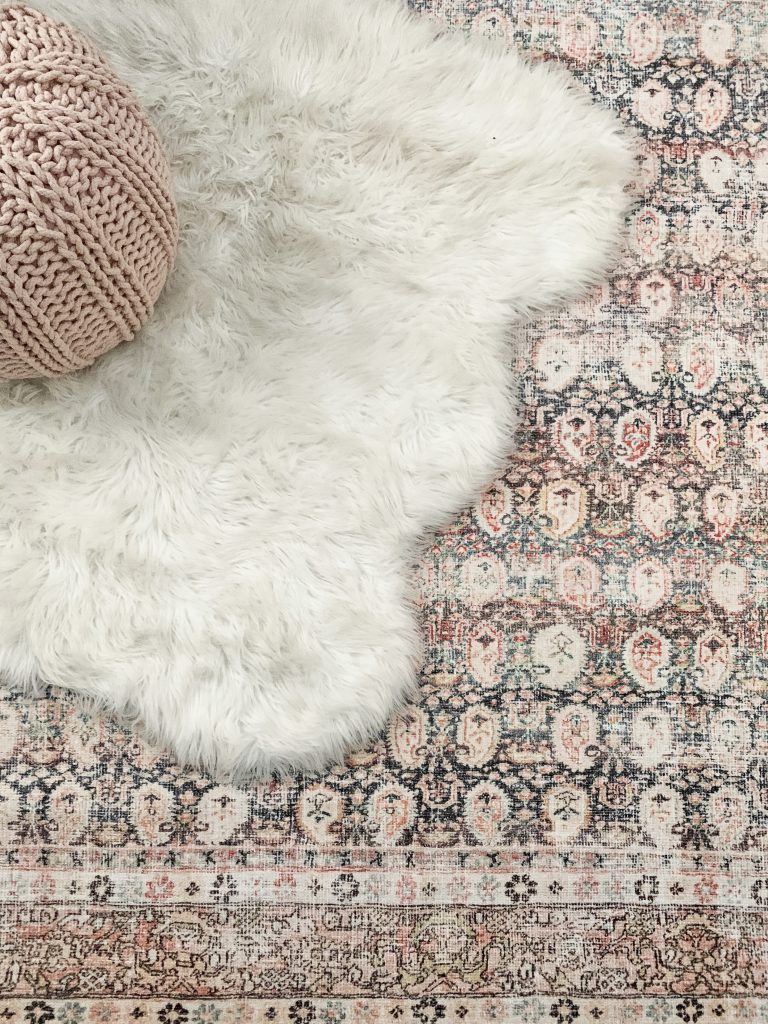 pink rug with faux fur rug layered on top